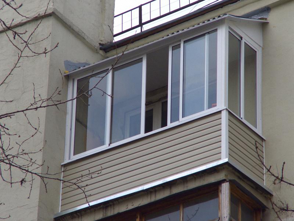 Холодное остекление балкона раздвижными окнами с выносом и крышей в Жуковском